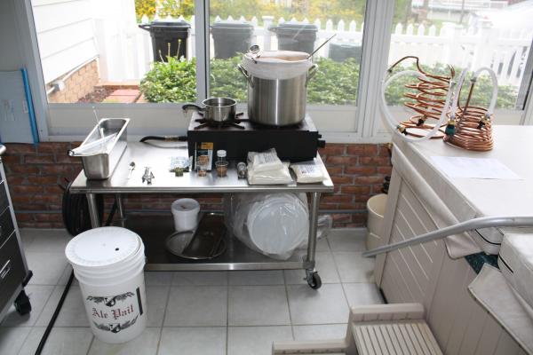 Picked up a stainless table from used restaurant supply store that holds 2-burner natural gas stove.  Brew in a 6.5 gallon stainless pot, keep container on left full of no-rinse sanatizer, wort chillers sitting on hot tub.  I set everything out in order t