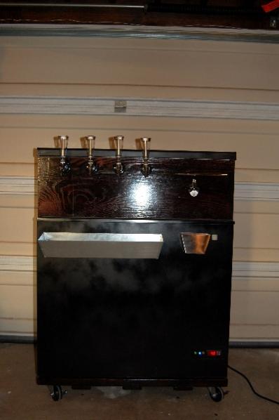 My completed keezer, a GE 7.0 CF.  Based on TomSD's design.  4 perlick faucets (with customizable tap handles), stainless steel handle for opening lid, mitered red oak collar, bottle opener + cap catcher, drip tray, custom electrical panel, and a custom d