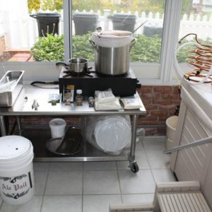 Picked up a stainless table from used restaurant supply store that holds 2-burner natural gas stove.  Brew in a 6.5 gallon stainless pot, keep container on left full of no-rinse sanatizer, wort chillers sitting on hot tub.  I set everything out in order t