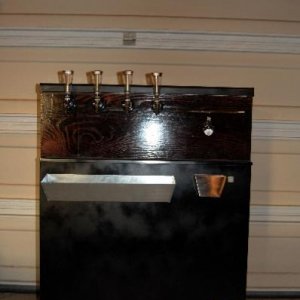 My completed keezer, a GE 7.0 CF.  Based on TomSD's design.  4 perlick faucets (with customizable tap handles), stainless steel handle for opening lid, mitered red oak collar, bottle opener + cap catcher, drip tray, custom electrical panel, and a custom d